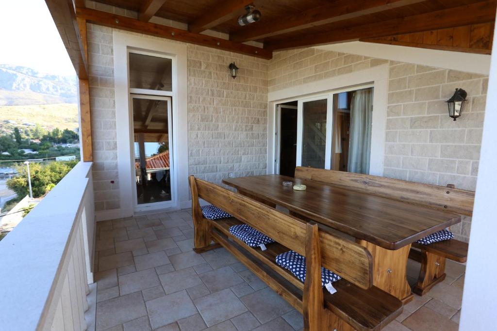 porche con mesa de madera y bancos en Apartment Beach, en Split