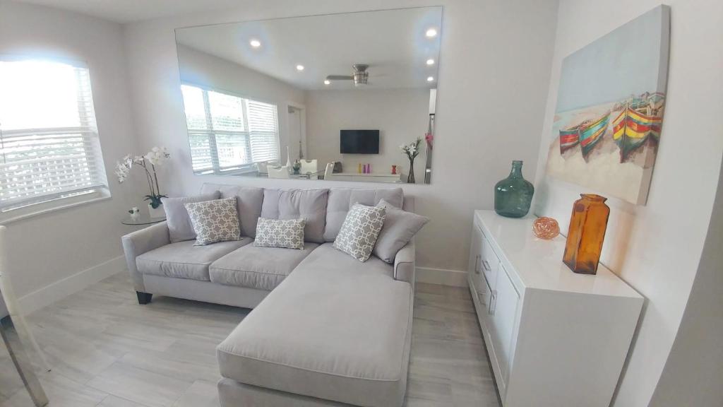 a white living room with a couch and a table at Pompano Beach Hidden Gem in Pompano Beach