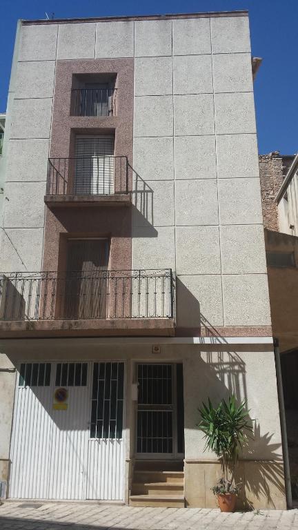 un edificio con un balcón en el lateral. en Can Marti, en Alfara de Carles