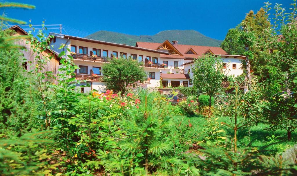 ein großes Gebäude inmitten eines Gartens in der Unterkunft Alpenpension Birkenhof in Grünau im Almtal