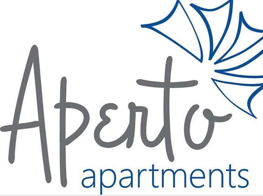 una señal para un par de apartamentos con una mariposa en Aperto Apartments en Mykonos ciudad