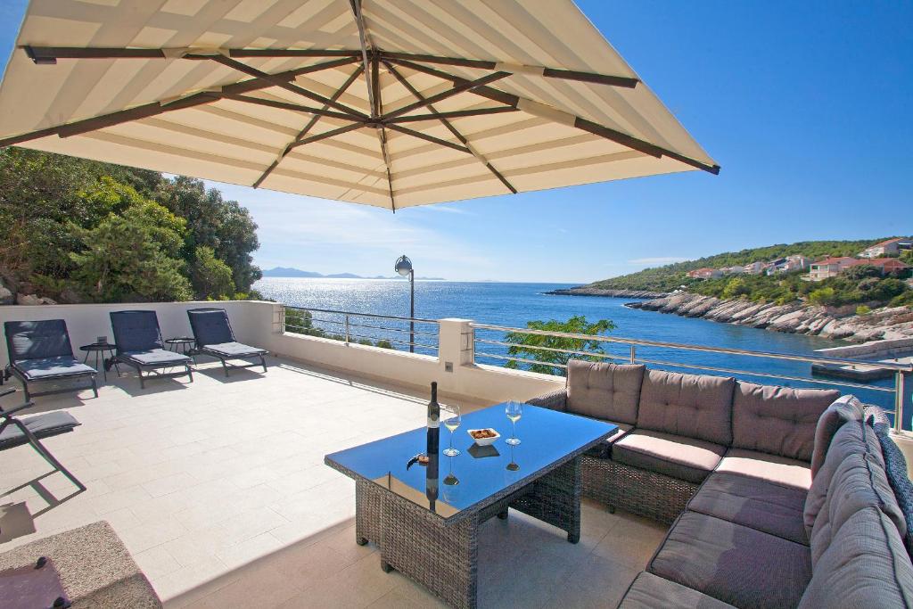 a patio with a couch and an umbrella at Nerica Apartment in Zavalatica