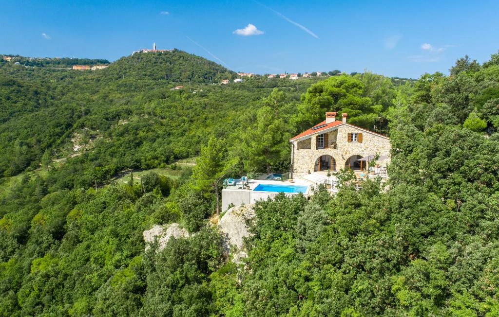 a house on the side of a hill with trees at Villa Bogijeva in Rabac