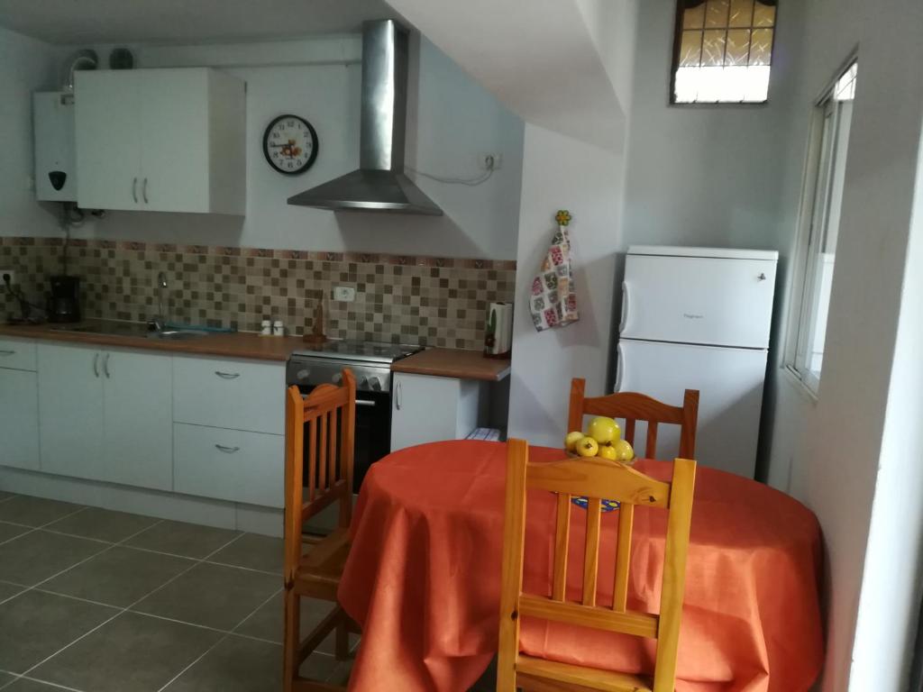 cocina con mesa, 2 sillas y fogones en Casa La Terraza, en Vallehermoso