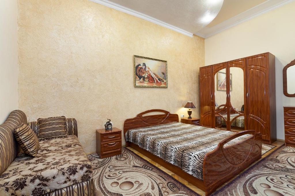 リヴィウにあるLvivPodobovo Apartmentsのベッドルーム(ベッド1台、ソファ付)