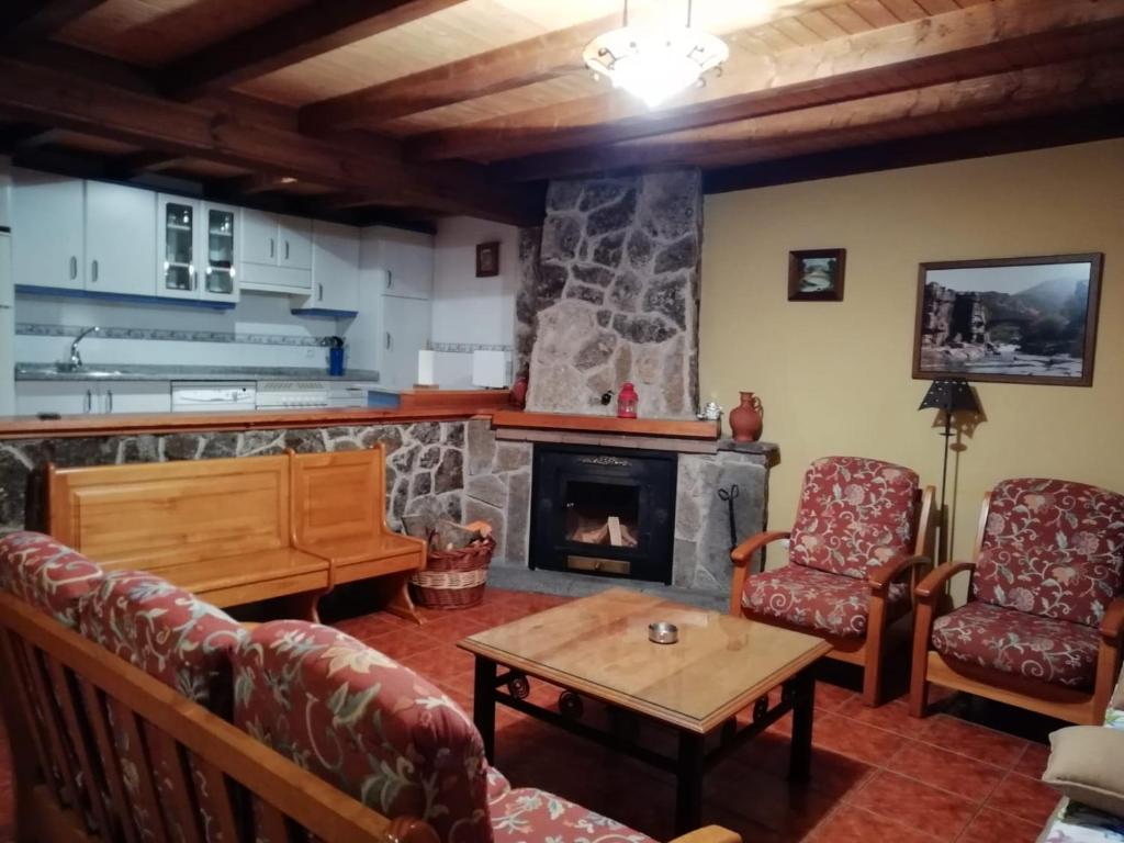 sala de estar con sofás y chimenea en La Puente 10 de Gredos, en Hoyos del Espino