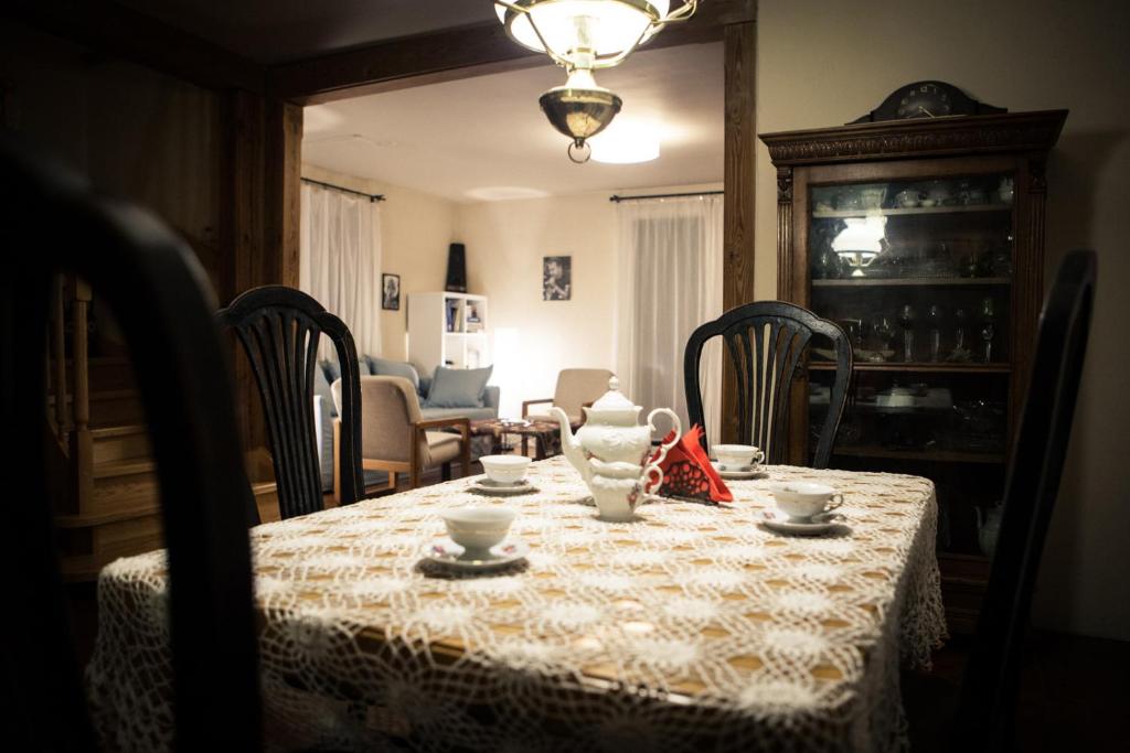 - une table à manger avec un vase et des tasses dans l'établissement KrakowHouse, à Libertów