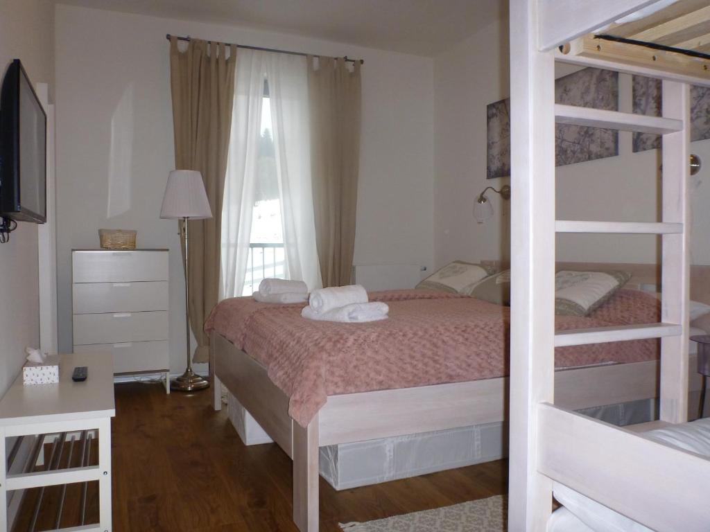 sypialnia z dwoma łóżkami piętrowymi i oknem w obiekcie Apartmán Jestřáb 5 w Jańskich Łaźniach