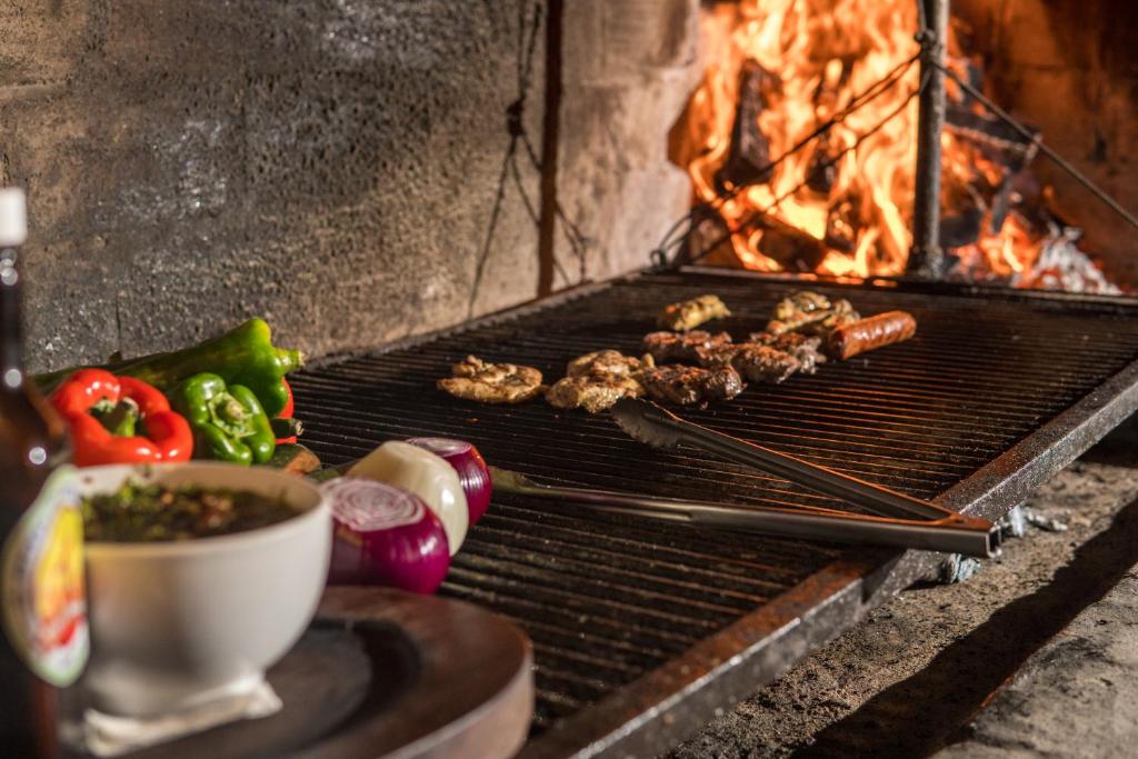 a grill with meat and vegetables next to a fire at Splash Inn Dive Resort & Villas in West End
