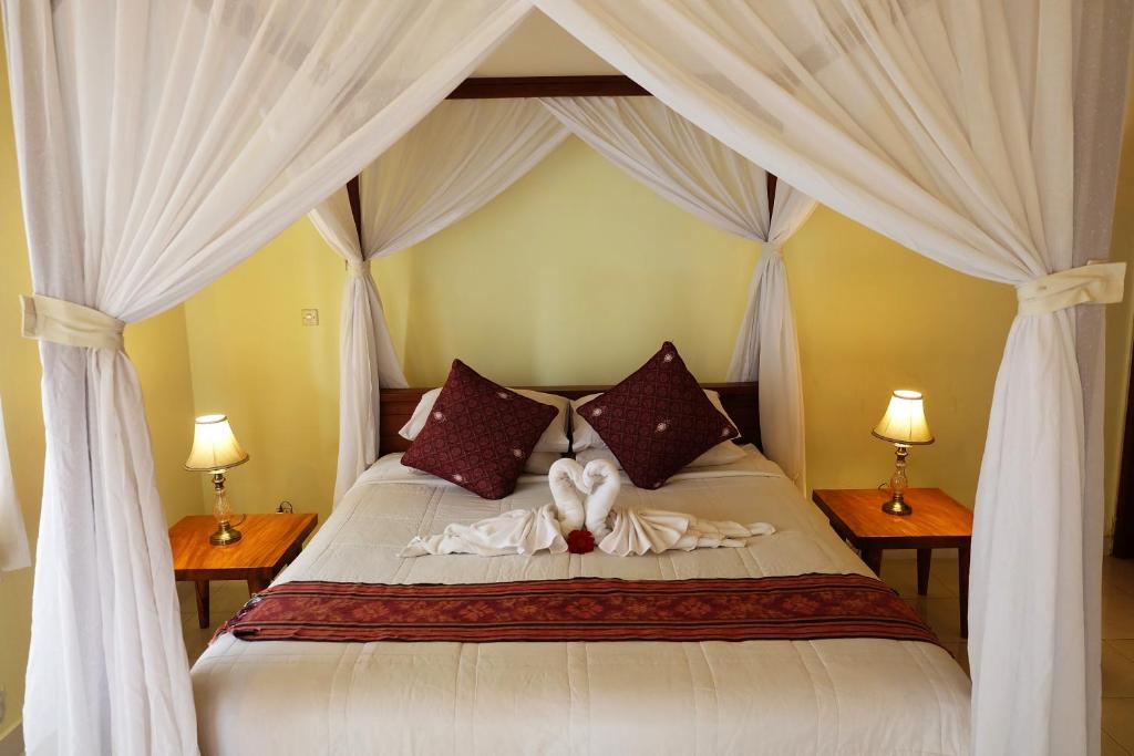 una camera da letto con un letto con due cuori sopra di Rendira Villa ad Ubud
