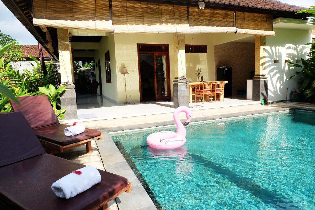 basen z różowym łabędziem w wodzie w obiekcie Rendira Villa w mieście Ubud