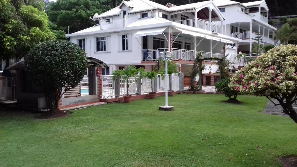 uma grande casa branca com um guarda-chuva num quintal em chemin neuf em Trois-Rivières