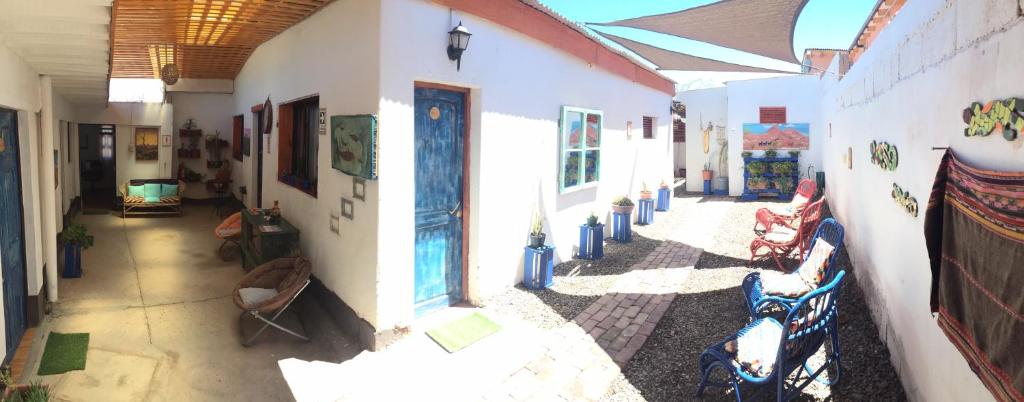 a hallway of a building with chairs and paintings on the walls at Hostal Siete Colores in San Pedro de Atacama