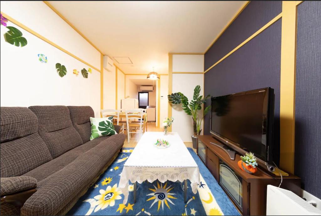 - un salon avec un canapé et une télévision dans l'établissement Kyorakuya, à Kyoto