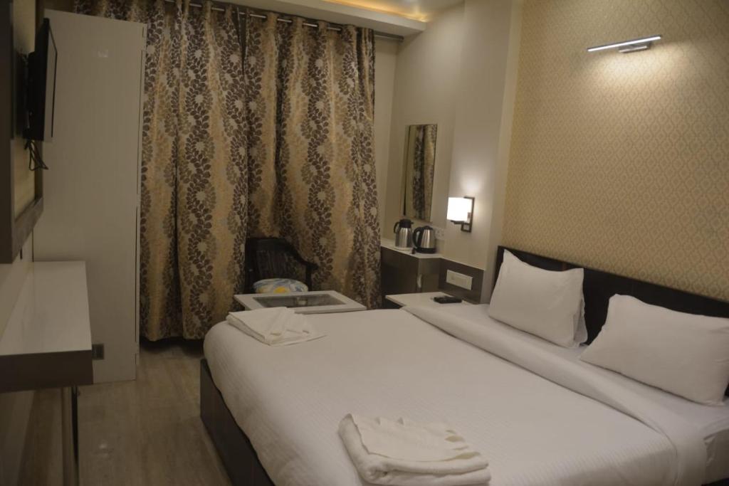 a hotel room with two beds and a window at Hotel Varanasi Heritage in Varanasi