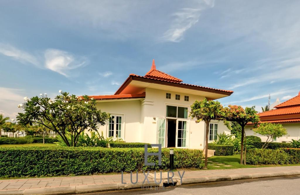 une maison blanche avec un toit orange dans l'établissement 2 Bedroom Private Pool Villa B100, à Hua Hin