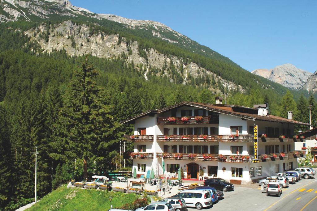 un hôtel avec des voitures garées devant une montagne dans l'établissement Nord Hotel, à Cortina dʼAmpezzo