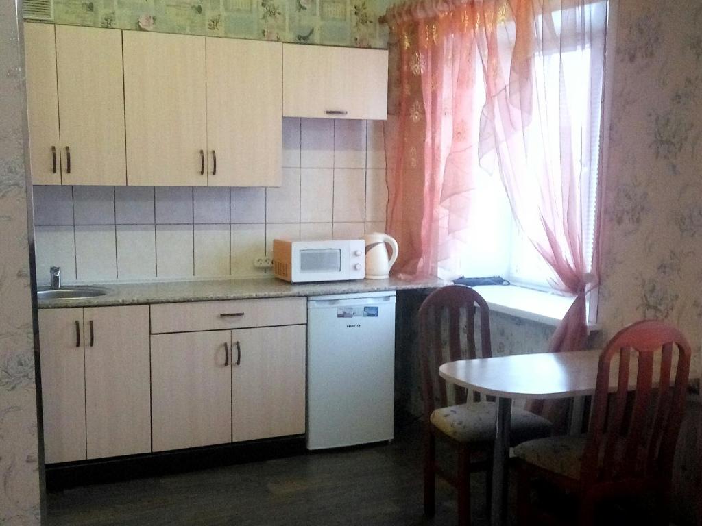 a small kitchen with a table and a microwave at Zavenyagina 4 Apartment in Noril'sk