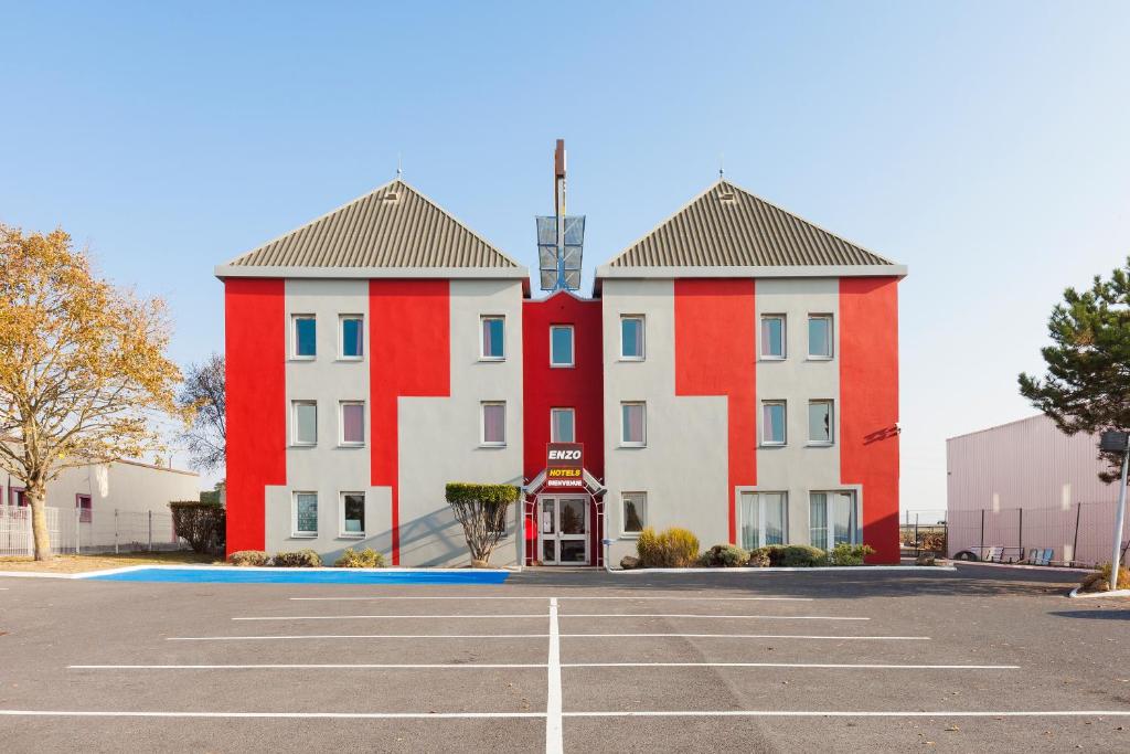 um edifício com dois edifícios vermelhos e brancos em ENZO HOTELS Chalons en Champagne em Saint-Martin-sur-le-Pré