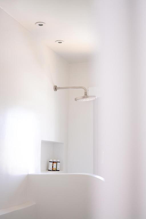 a white kitchen with a light fixture on the ceiling at Pénde Suites in Livadion