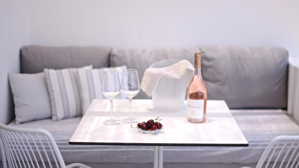 a table with a bottle of wine and two glasses at Pénde Suites in Livadion
