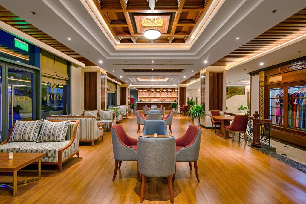 a lobby with couches and tables and chairs at DLG Hotel Danang in Da Nang