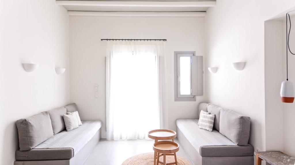 a living room with two gray couches and a table at Pénde Suites in Livadion