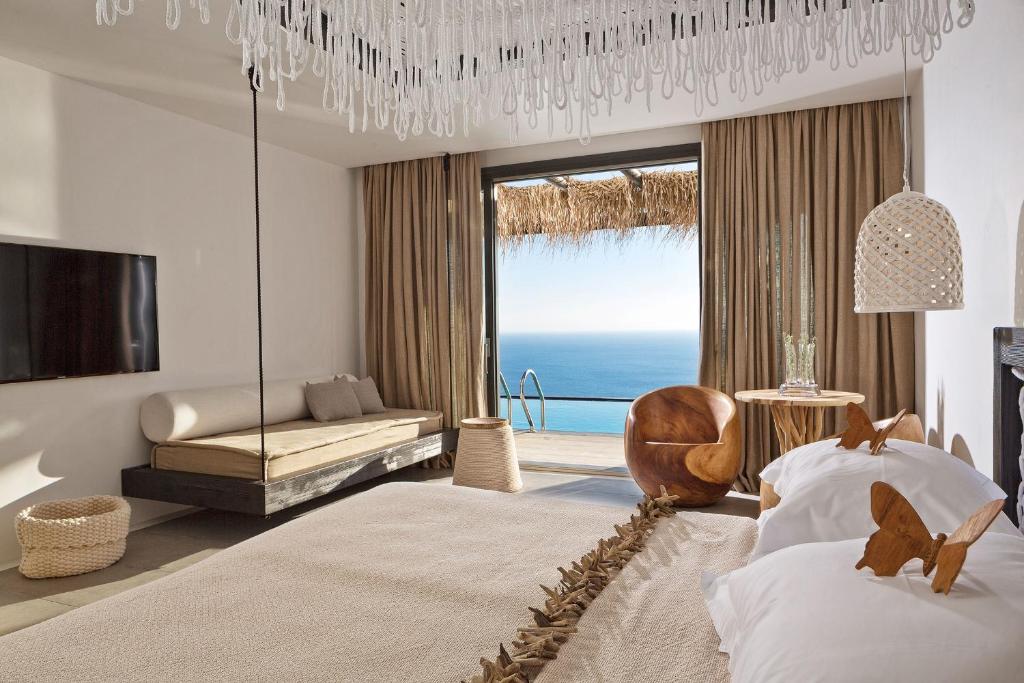a bedroom with two beds and a view of the ocean at Myconian Utopia Relais & Chateaux in Elia Beach