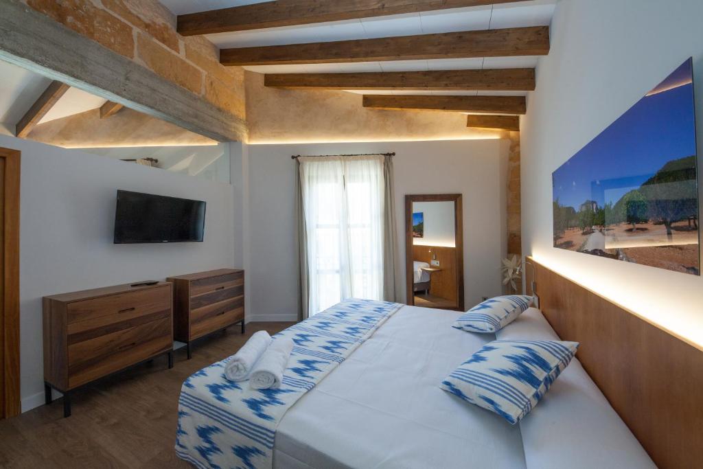 a bedroom with a large bed and a television at Ca'n Bestard - Adults Only in Lloseta