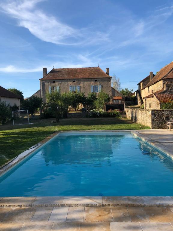 a blue swimming pool in front of a house at Chatel de Bierre in Sigy-le-Châtel