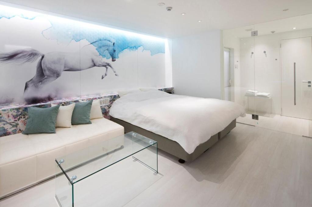 1 dormitorio con 1 cama, 1 sofá y 1 pintura en HOTEL LYISTA (Adult Only), en Hanamaki