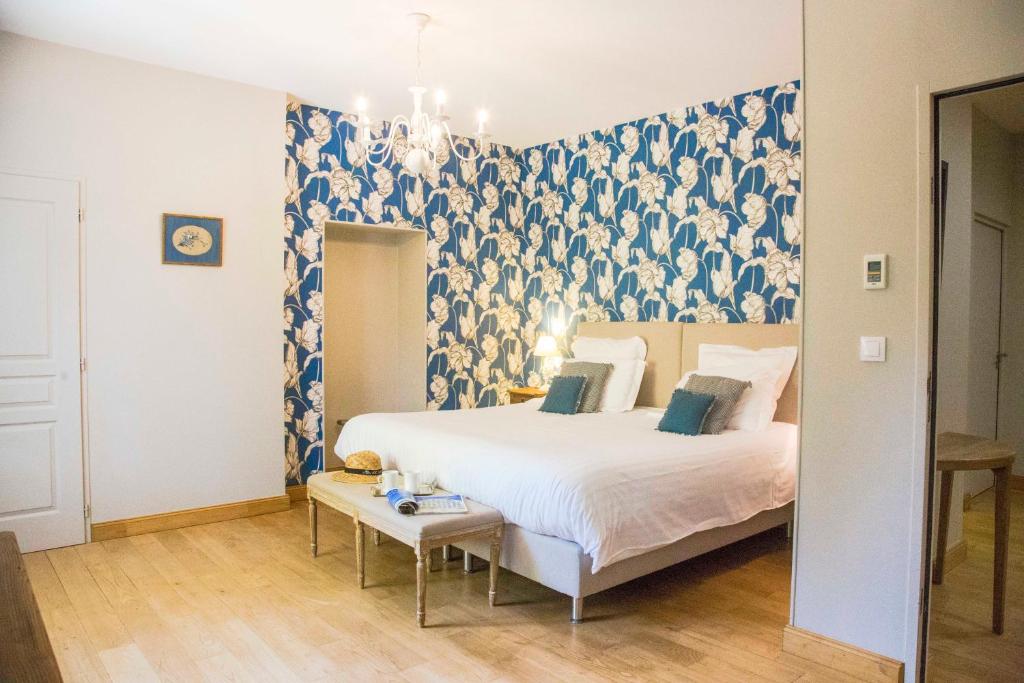 Salles-dʼAudeにあるシャトー シャトー ペック-セルイランのベッドルーム1室(青と白の壁紙のベッド1台付)