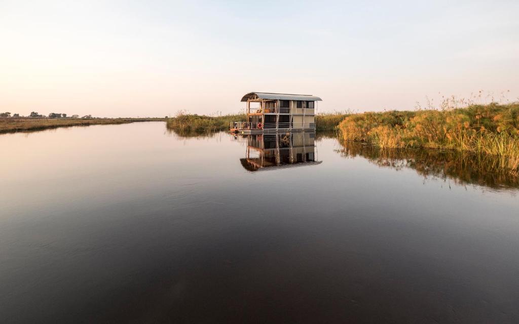 a small boat in the middle of a river at The Namushasha River Villa in Kongola