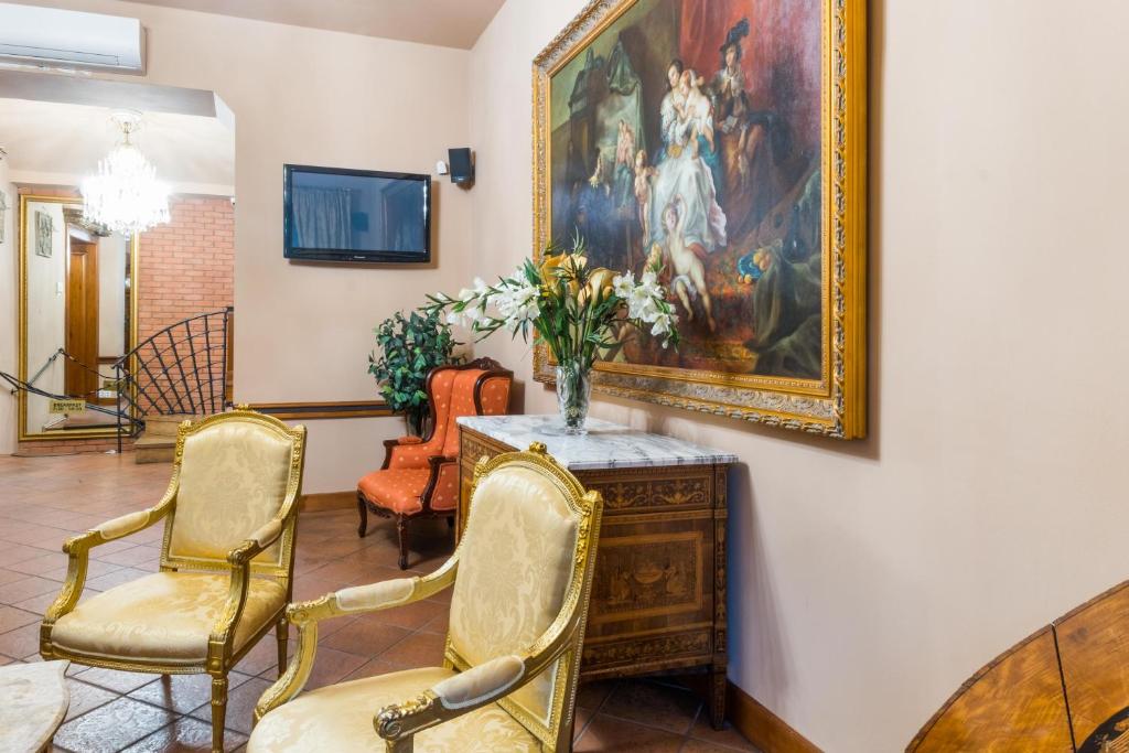 salon z 2 krzesłami i obrazem na ścianie w obiekcie La Fenice w Pradze