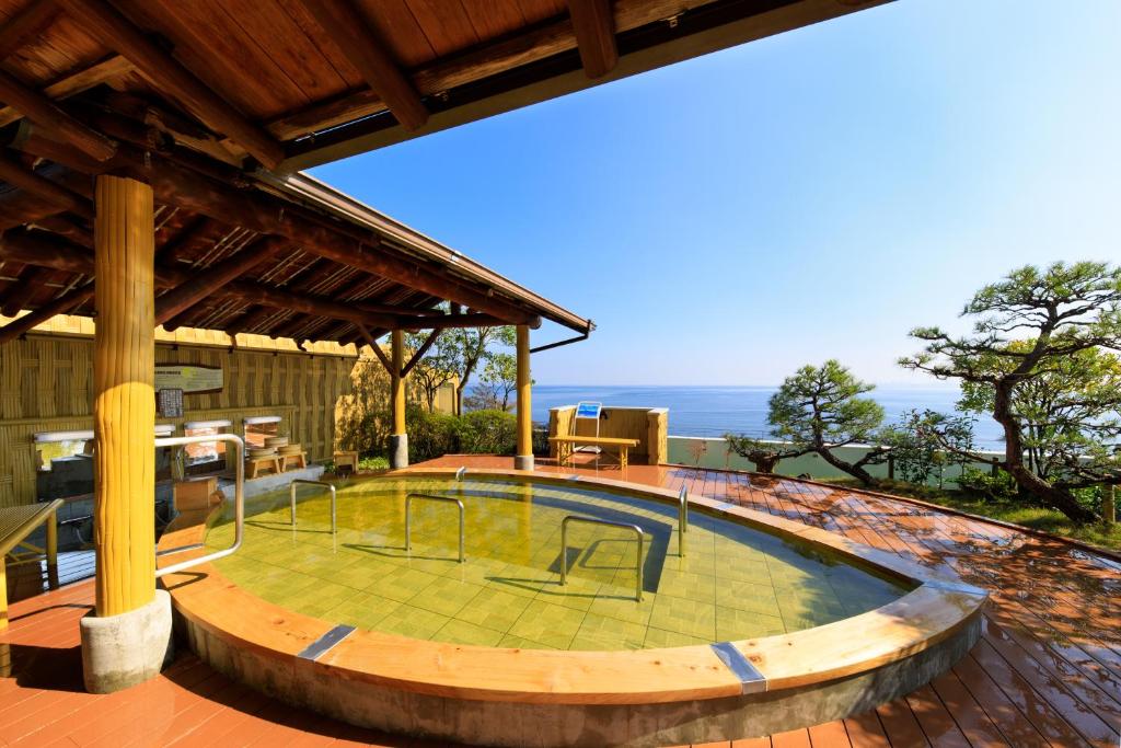 a house with a pool in the middle of a patio at Seaside Hotel Mimatsu Ooetei in Beppu