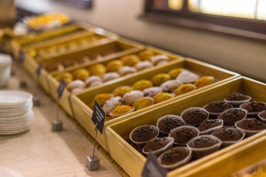 a row of trays of donuts on a counter at AZIMUT Hotel Siberia in Novosibirsk