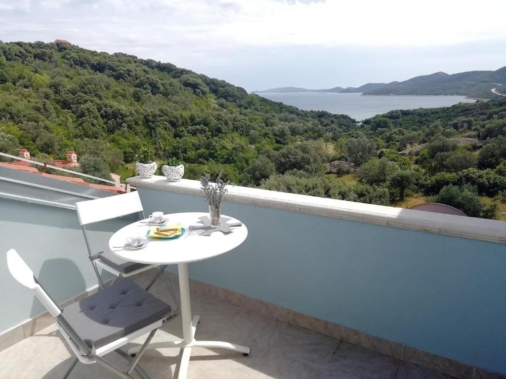 un tavolo bianco e una sedia su un balcone con vista di Sunny Blue Apartament a Nerezine (Neresine)