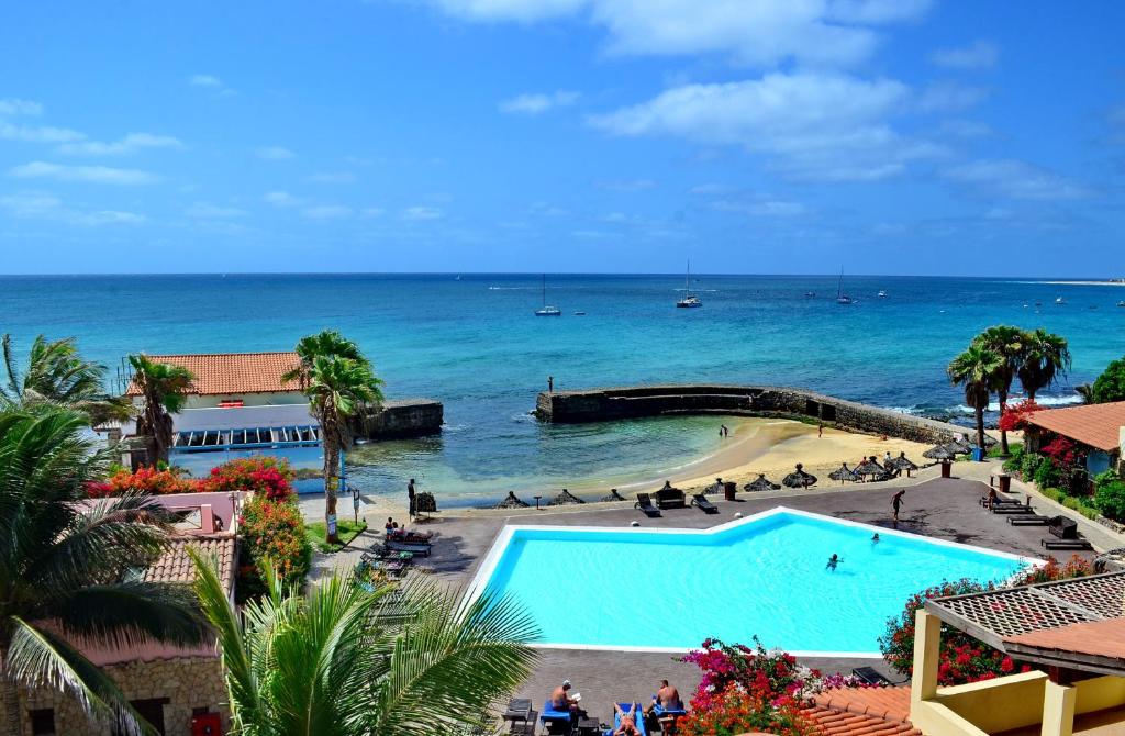 uma vista para uma piscina e para o oceano em Porto Antigo Hotel BB em Santa Maria
