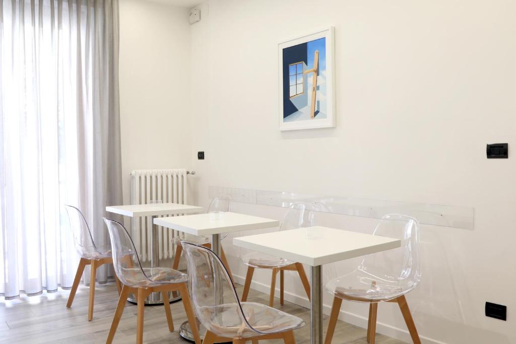 une salle à manger avec des tables et des chaises blanches dans l'établissement Primo a destra, à Campobasso