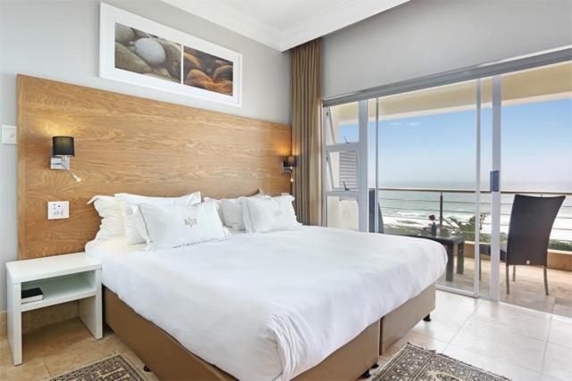 a bedroom with a large bed with a view of the ocean at Vetho House in Ballito