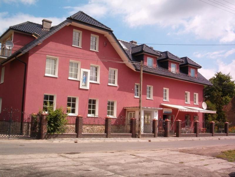 duży czerwony dom z płotem przed nim w obiekcie Gościniec ELLA INN Lipniki w mieście Lipniki