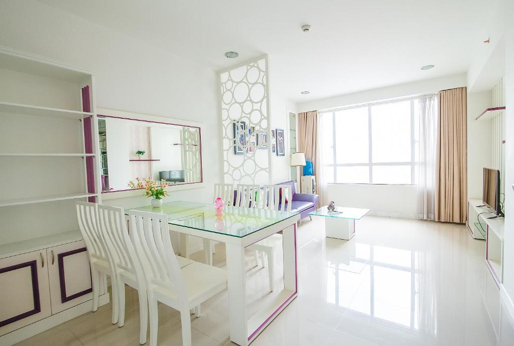 une salle à manger avec une table en verre et des chaises blanches dans l'établissement Sunrise City - 2 Bed Room - Full Furniture - City View, à Hô-Chi-Minh-Ville