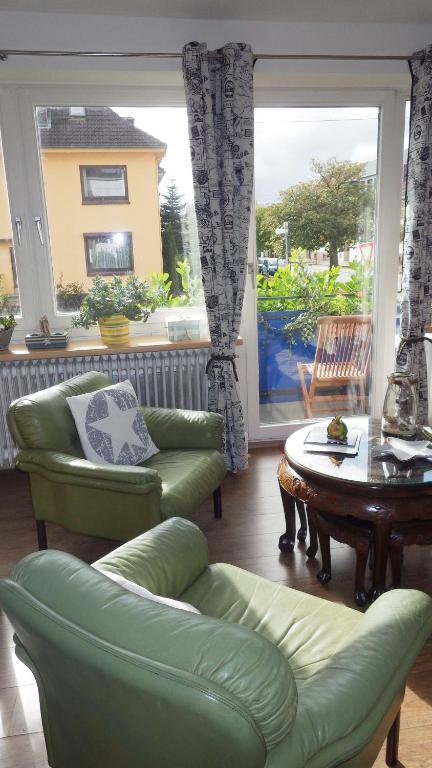 - un salon avec un canapé vert et une table dans l'établissement Ferienwohnung Seesternchen, à Bremerhaven