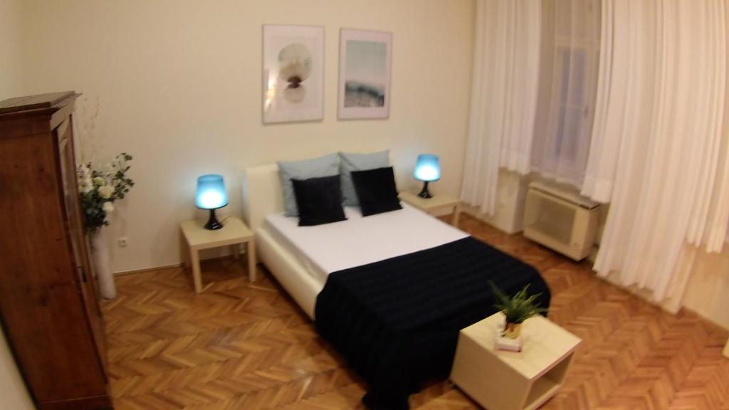 ブダペストにあるOpera Dream Apartmentのベッドルーム1室(ベッド1台、ランプ2つ、テーブル2台付)