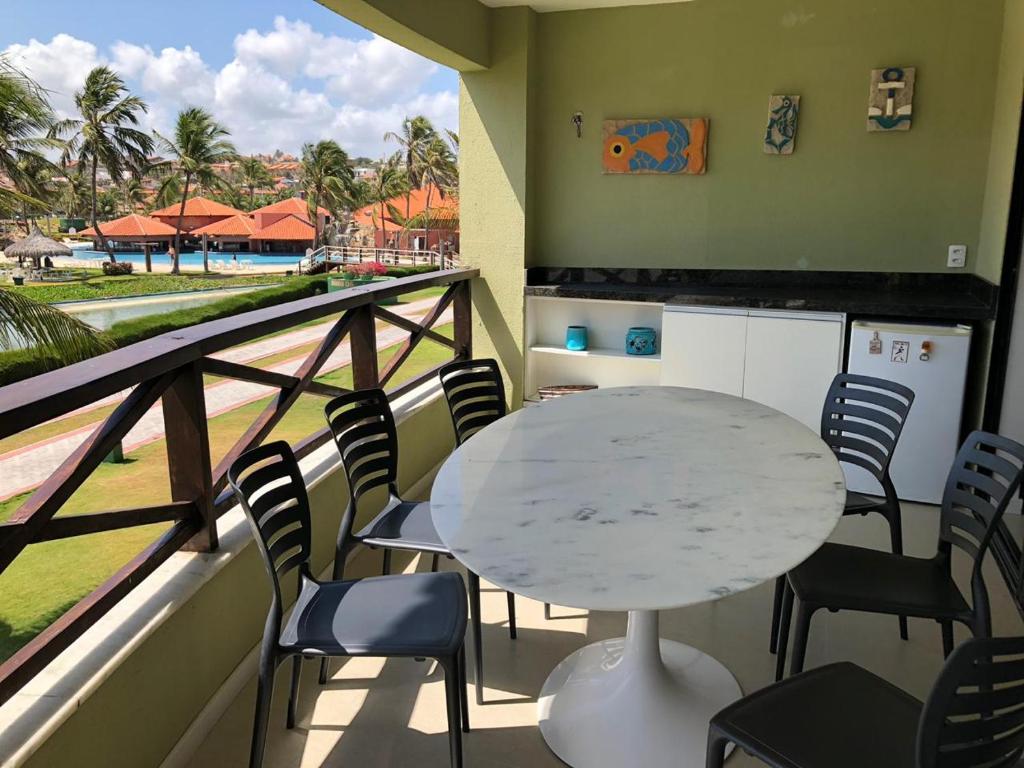 a table and chairs on a balcony with a view of the beach at Aquaville Resort in Mangabeira
