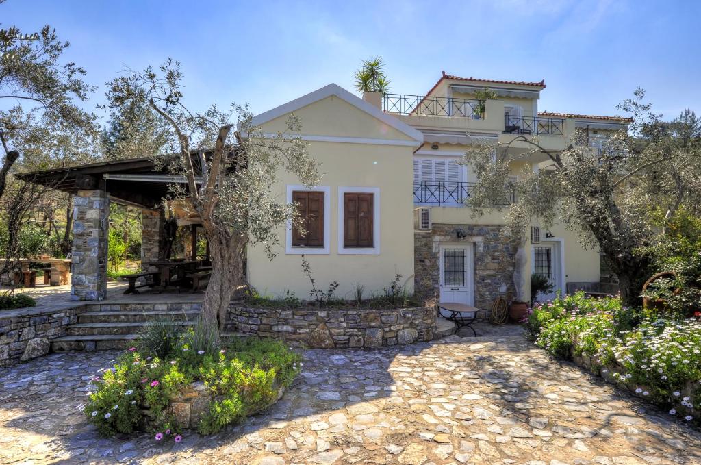 a white house with a tree in front of it at Gera's Olive Grove - Elaionas Lesvou in Perama