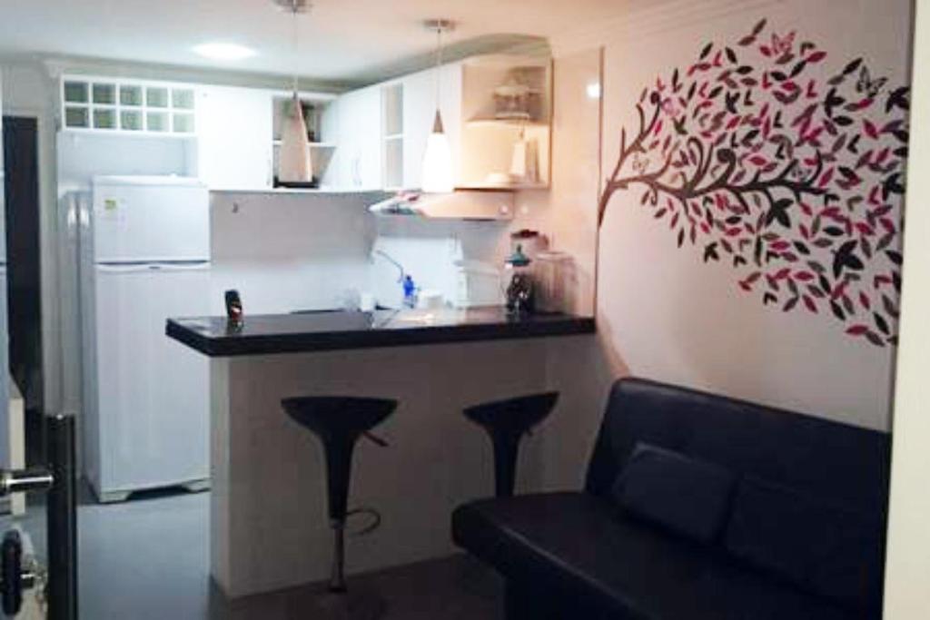 a kitchen with a counter and a bar with stools at Apto na Praia de Guaibim in Guaibim