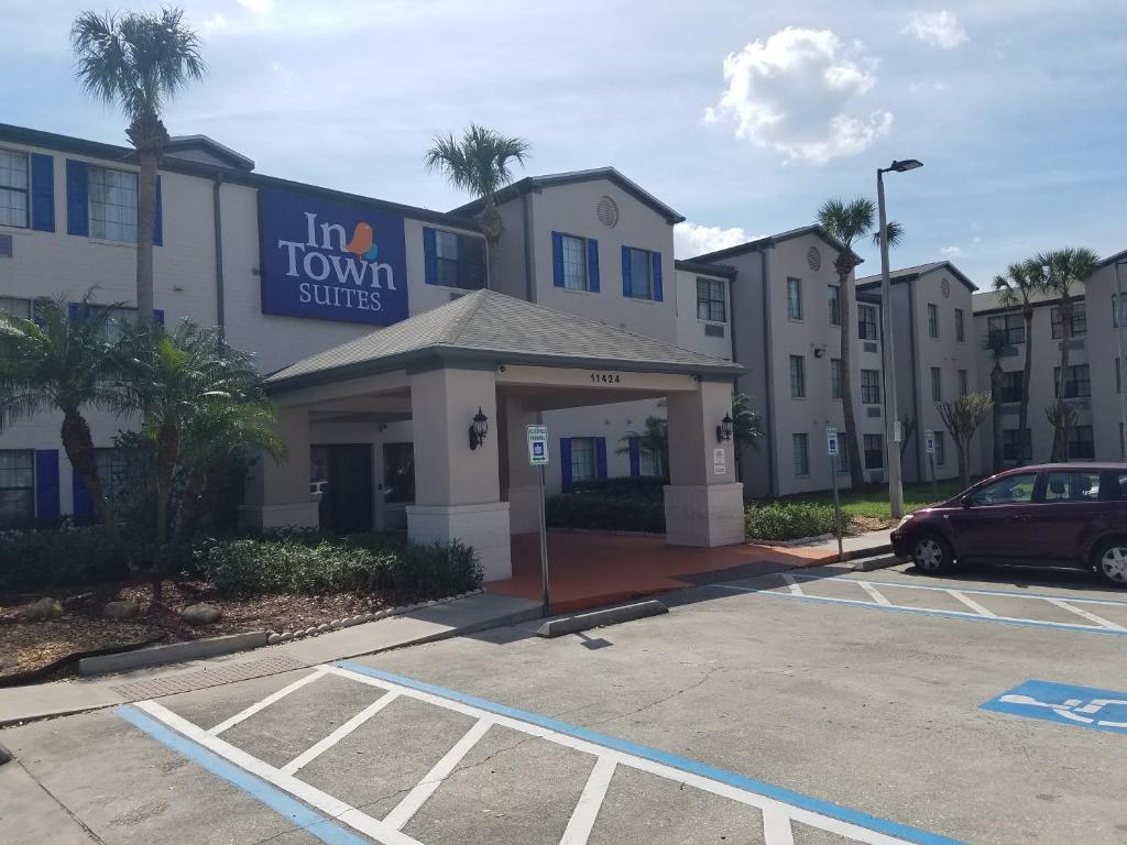um edifício com um carro estacionado num parque de estacionamento em InTown Suites Extended Stay Select Orlando FL - UCF em Orlando