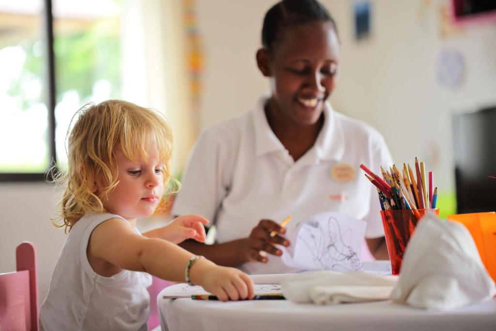 a woman and a little girl sitting at a table at The Residence Zanzibar in Kizimkazi