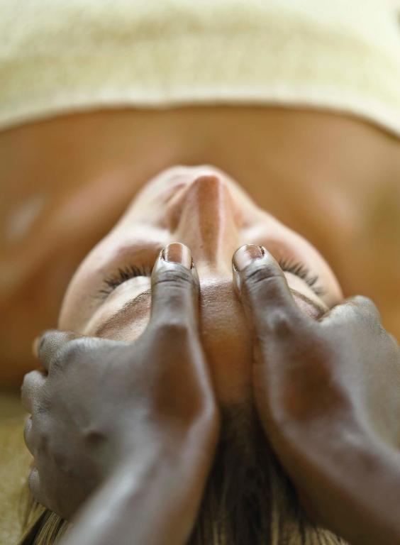 a person laying in a bed with their feet up at The Residence Zanzibar in Kizimkazi